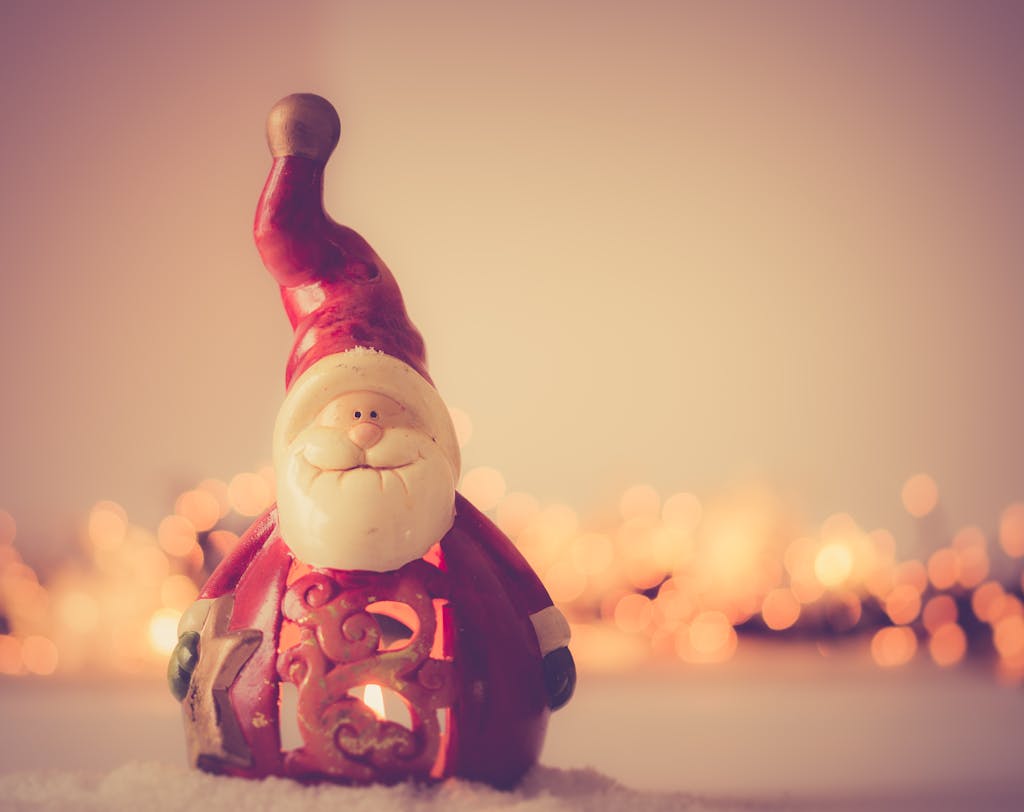 Charming Santa Claus figurine with festive bokeh lights creating a warm Christmas atmosphere.