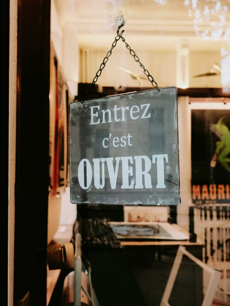 Charming French sign in a boutique storefront inviting customers inside.
