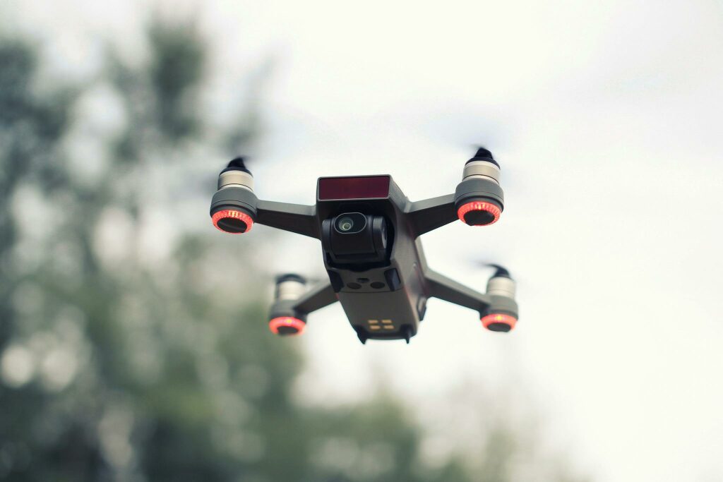 A modern drone flying with a blurred background, showcasing advanced technology and aviation innovation.