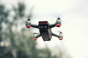 A modern drone flying with a blurred background, showcasing advanced technology and aviation innovation.