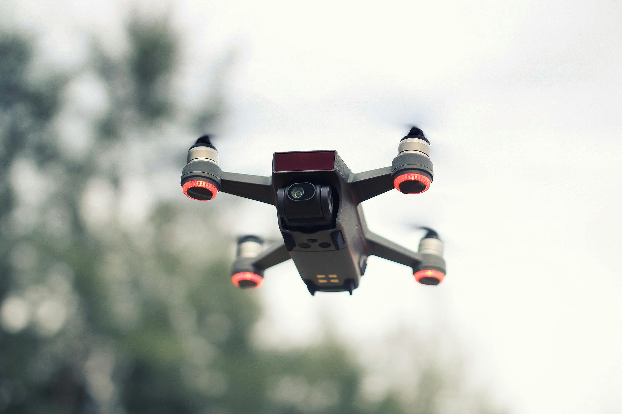 A modern drone flying with a blurred background, showcasing advanced technology and aviation innovation.